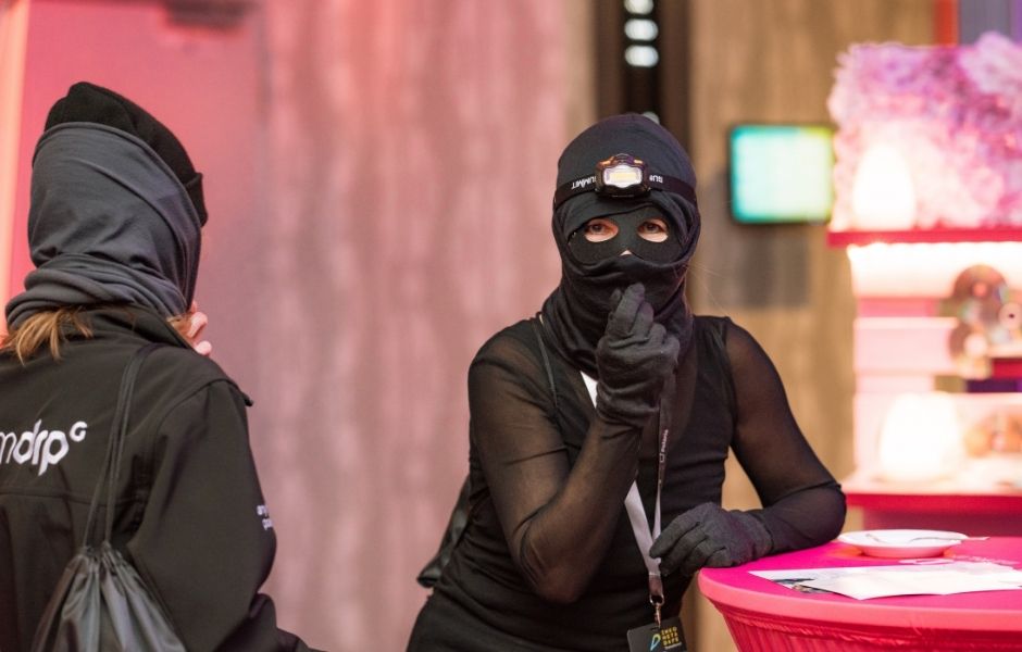 Zwei vermummte Menschen am Tisch