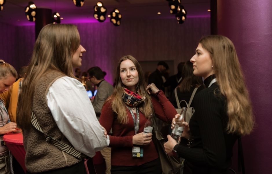Drei junge Frauen unterhalten sich im Foyer