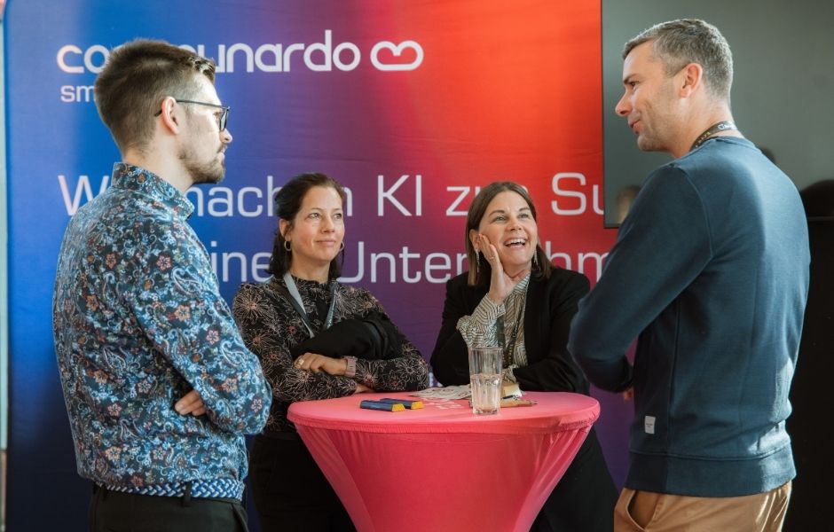 Gruppe von Menschen unterhält sich am Stand